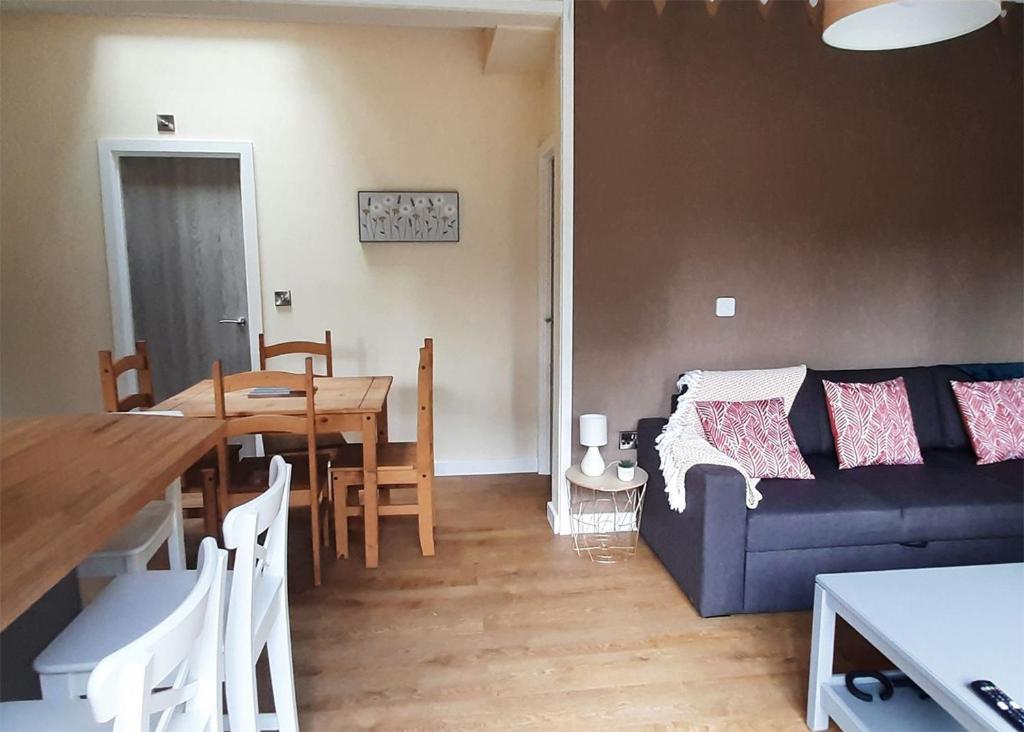 a living room with a blue couch and a table at Riverside Cabins in Shrewsbury