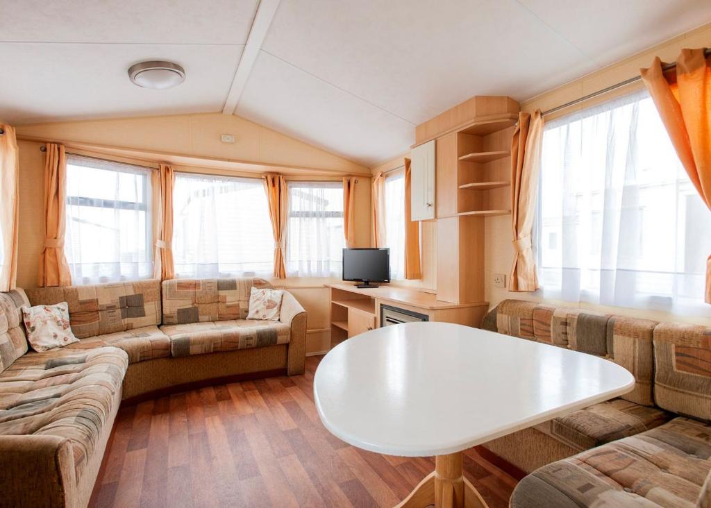 a living room with a couch and a table at Eastern Beach Caravan Park in Caister-on-Sea