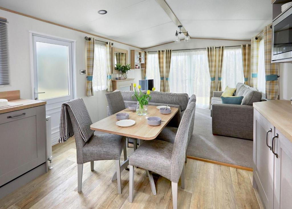 a kitchen and living room with a table and chairs at Willows Holiday Park in Withernsea
