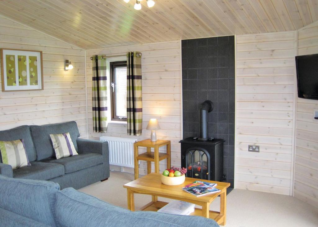 a living room with a couch and a stove at Wighill Manor Lodges in Newton Kyme