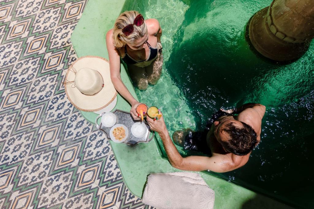 a man and a woman in the water with a surfboard at Abelia Traditional Riad - All Inclusive - 2023 traveler's Choice Award in Marrakech