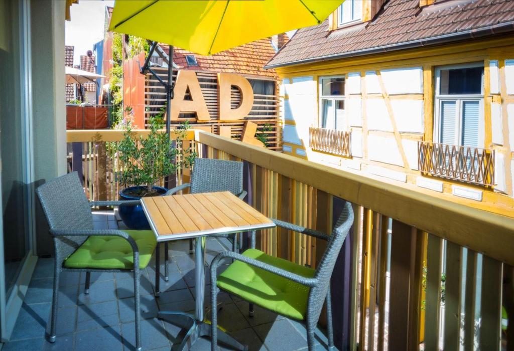 einen Tisch und Stühle auf einem Balkon mit Sonnenschirm in der Unterkunft Die FUHRMANN-SUITE, unser Deluxe-Apartment mit allem erdenklichen Komfort in Marktheidenfeld