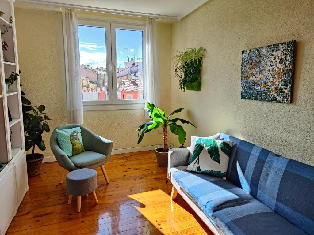 a living room with a blue couch and two chairs at Apartamento Plaza de la Paz in Haro