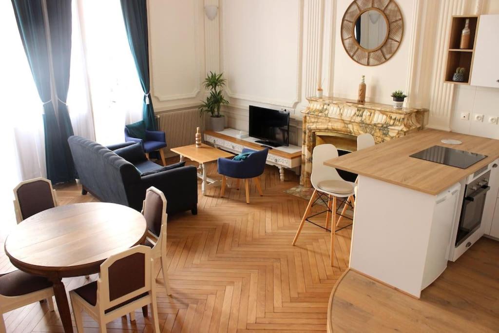 uma sala de estar com mesa e cadeiras e uma cozinha em Sublime appartement, chic et confortable. em Bourg-en-Bresse