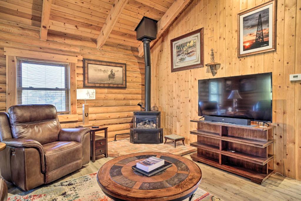 un soggiorno con TV, sedia e camino di Remote Cabin with Gas Stove Less Than 7 Mi to Town! a Glendo