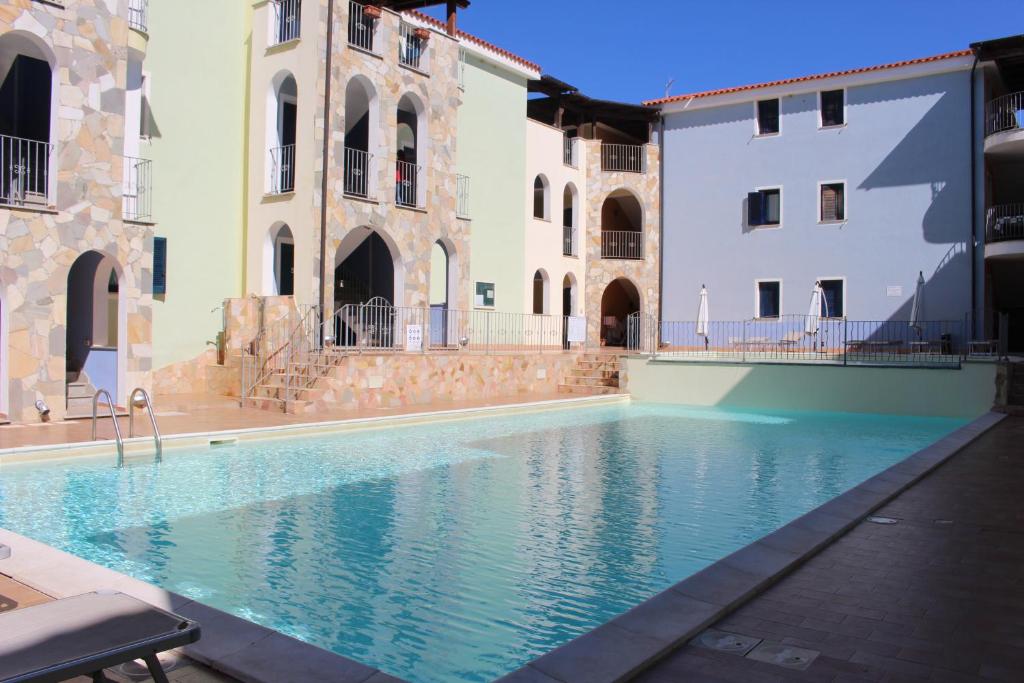 uma piscina num pátio com dois edifícios em Residence Valledoria 2 int 8 em Valledoria