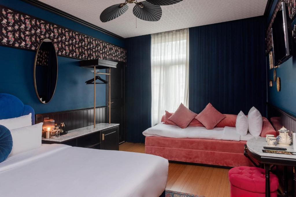 Duas camas num quarto com paredes azuis e almofadas vermelhas em Craves em Bruxelas