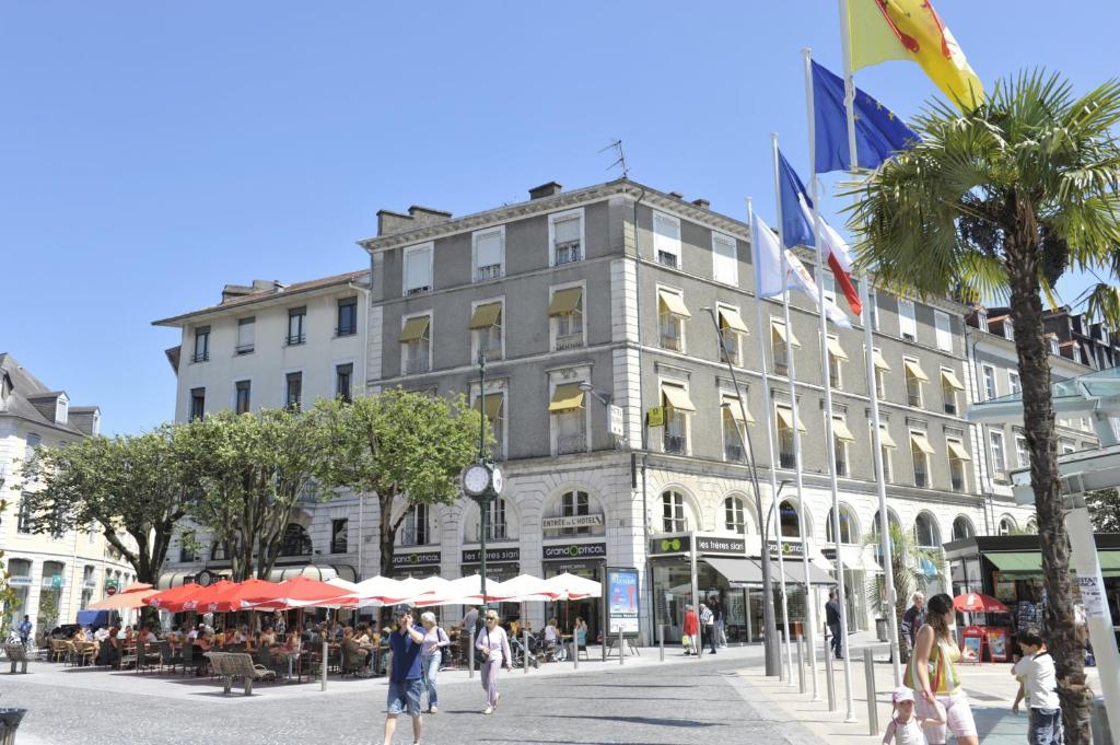 a large building with people walking in front of it at Hotel Le Bourbon Pau Centre in Pau