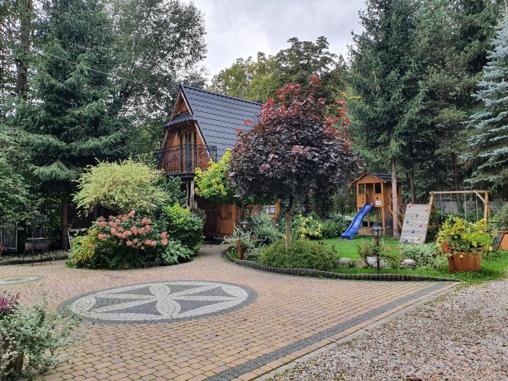 a house with a garden in front of it at Domek Góralski Chatka Puchatka in Poronin