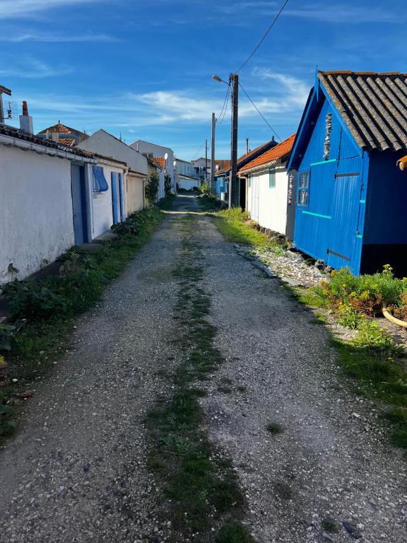 una calle vacía en un pueblo con un edificio azul en L'étoile de mer, en Bourcefranc