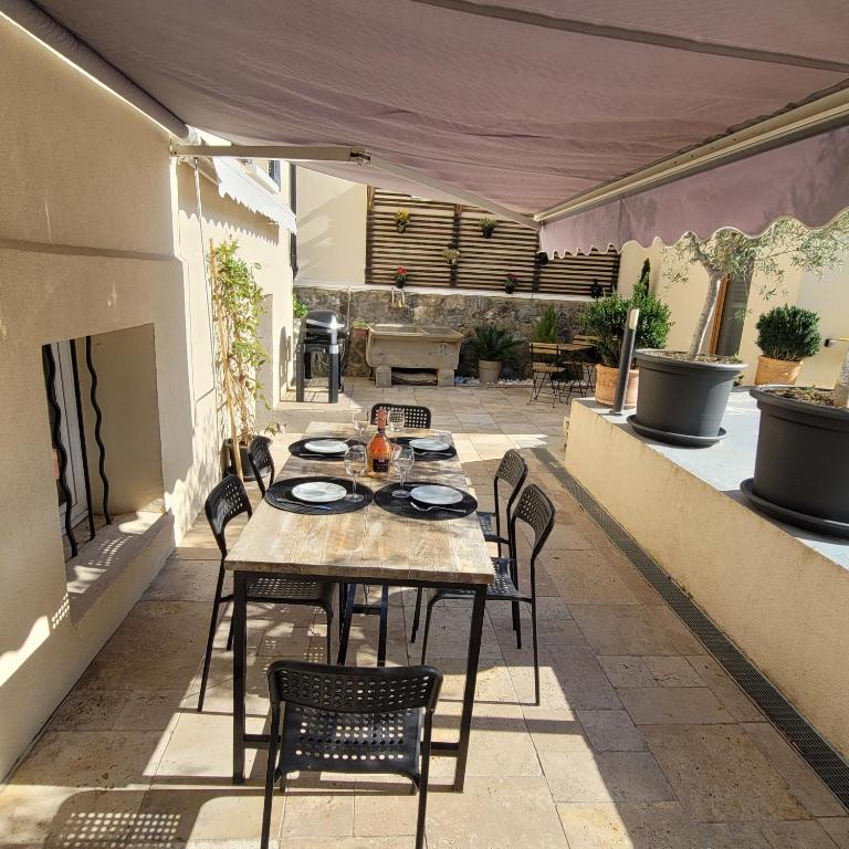 un patio avec une table et des chaises sur un patio dans l'établissement le petit sémaphore, à Saint-Raphaël