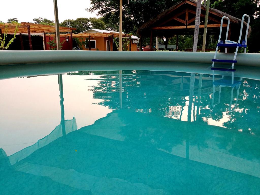uma piscina com uma cadeira azul e a água em ZenGarden Paraguay - Modernes und komfortables Haus Orchidee em San Lorenzo de la Frontera