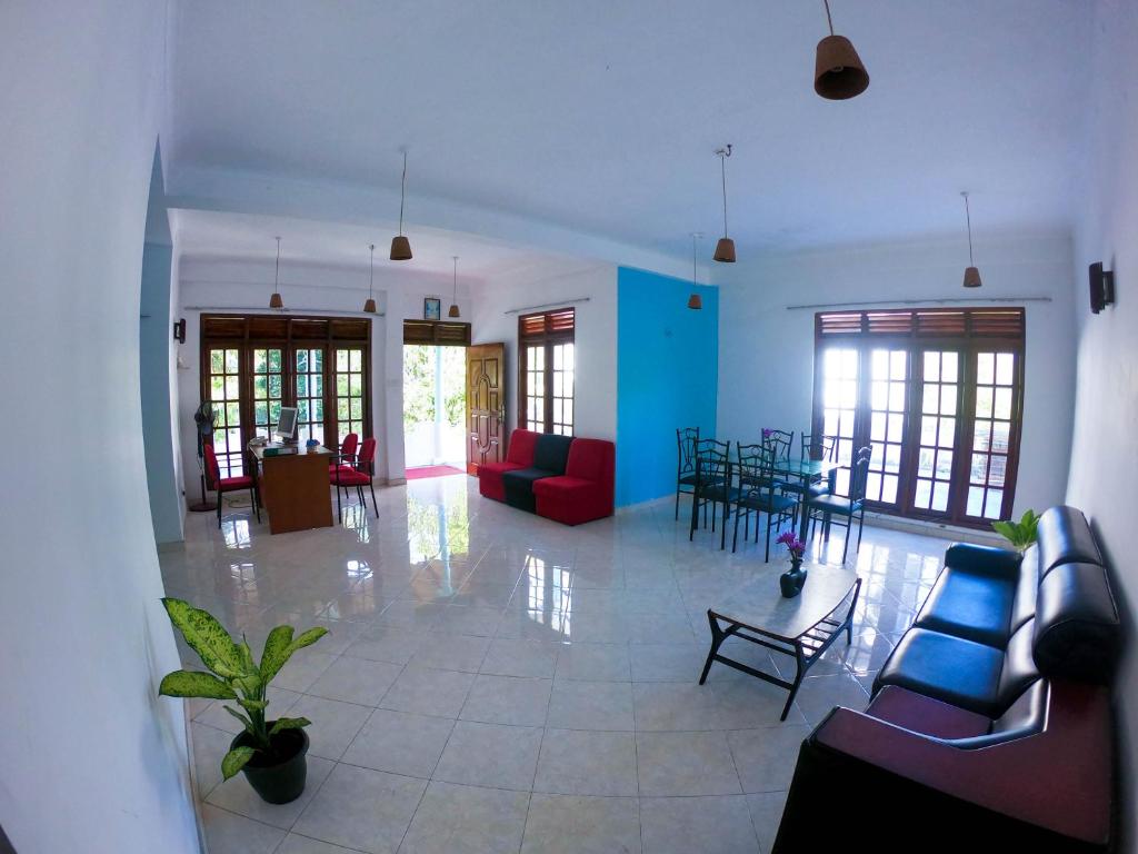 a living room with couches and a table and chairs at Blue Waves Madiha in Matara