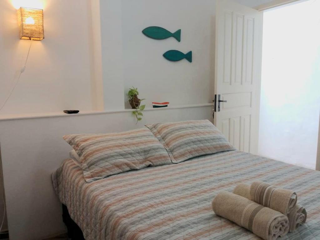 - une chambre avec un lit et une couette à rayures dans l'établissement Suítes Recanto cama e café, à Arraial do Cabo