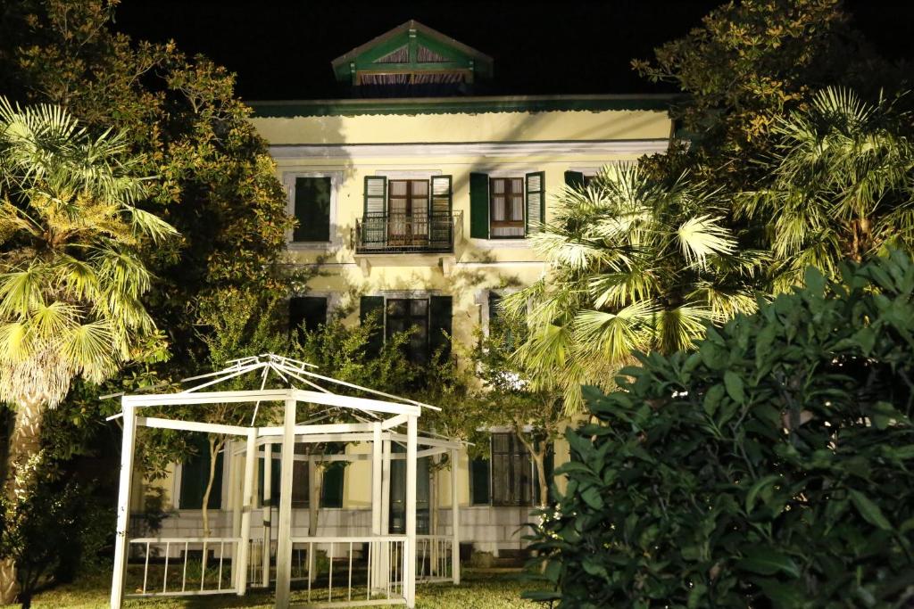 una casa blanca con un cenador frente a ella en Hotel Damian Park Hotel Delle Magnolie en Trofarello