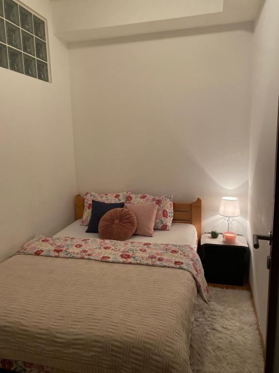 a bedroom with a bed with pillows on it at Apartman Bella Novi Beograd in Bežanija