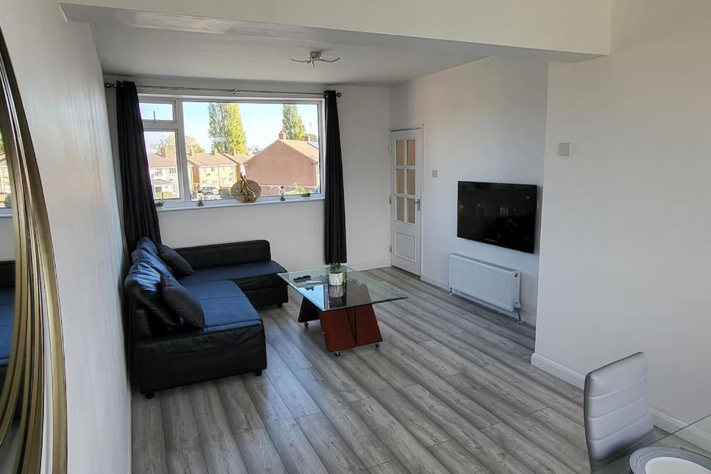 a living room with a couch and a coffee table at Newly refurbished 3 bedroom flat in Bedworth