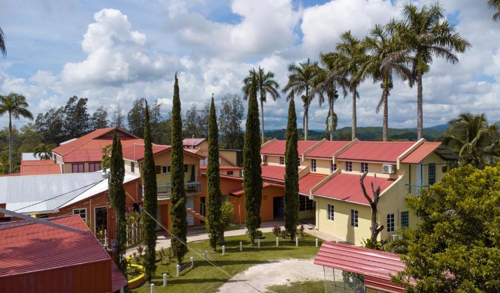un grupo de edificios con palmeras y un parque en Rumors Resort Hotel en San Ignacio