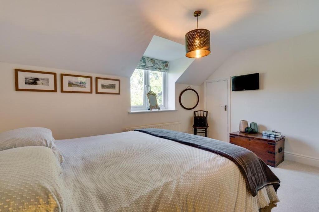 a bedroom with a large bed and a window at Mews Cottage Arnside - 2 Bedroom Cottage in Arnside