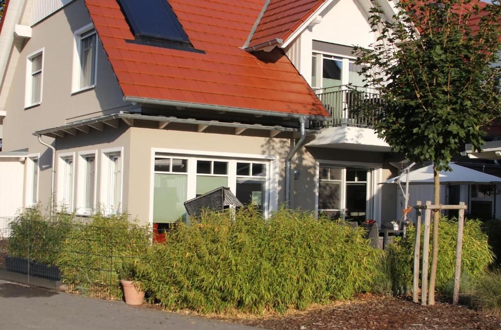 a white house with an orange roof at Ferienwohnung Stoneyard´s in Wustrow