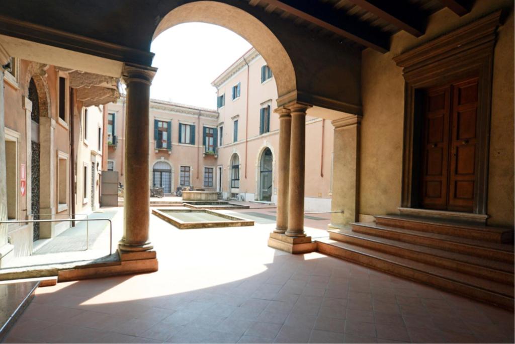 un pasillo vacío en un edificio antiguo con un arco en B&B al 19, en Verona