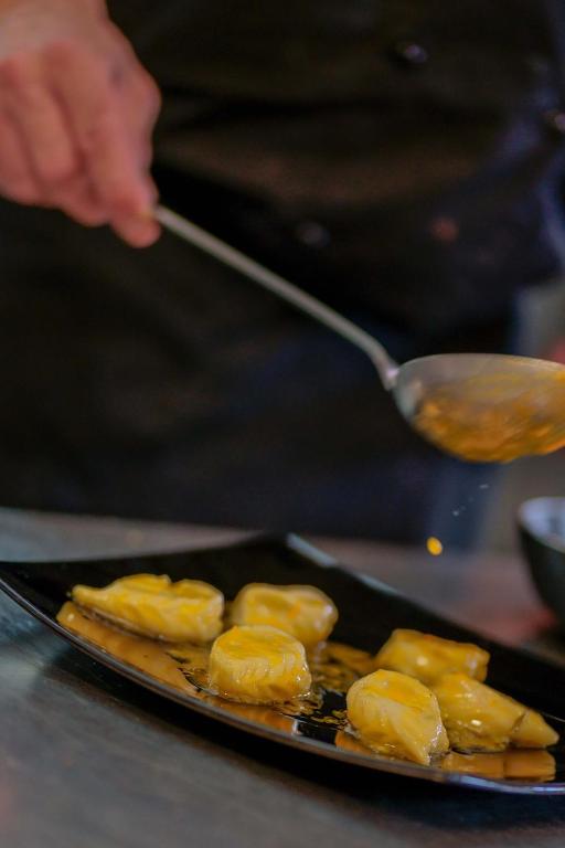 a person holding a spoon and a plate of food at Il Monastero in Geremèas