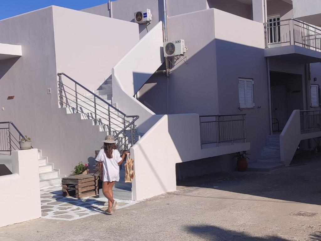 Una mujer caminando por las escaleras de un edificio en Bee life apts, Sweet house, en Kokkinos Pirgos