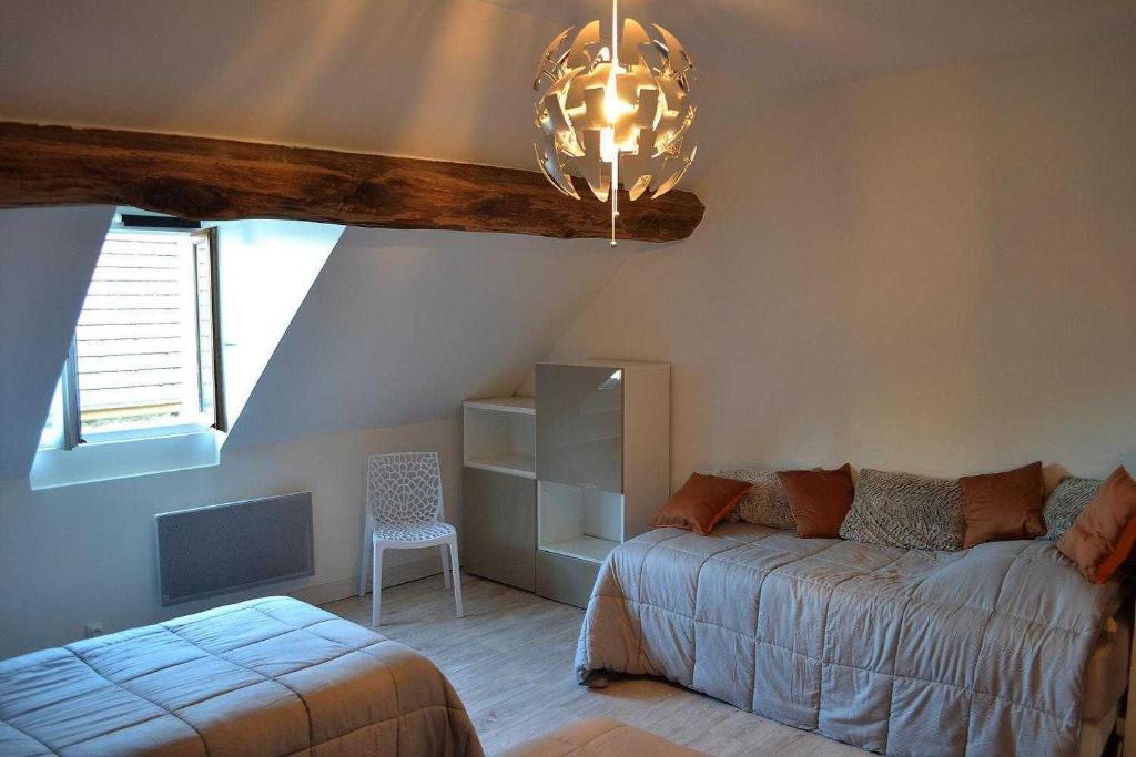 - un salon avec un lit et une fenêtre dans l'établissement Gîte des remparts, à Bèze