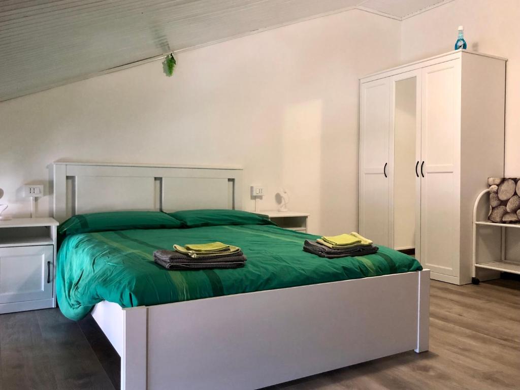 um quarto com uma cama grande e lençóis verdes em Appartamento “Del TuF” in Sondrio Centro em Sondrio