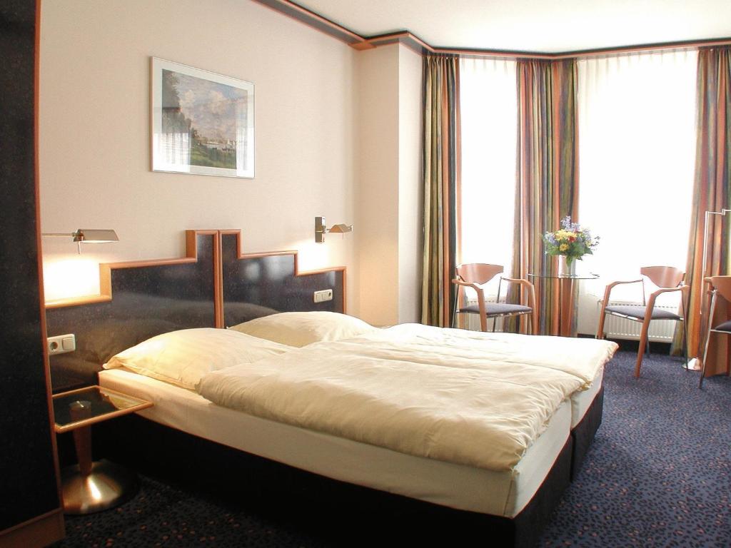ein Hotelzimmer mit einem Bett in einem Zimmer in der Unterkunft Insel Hotel in Köln
