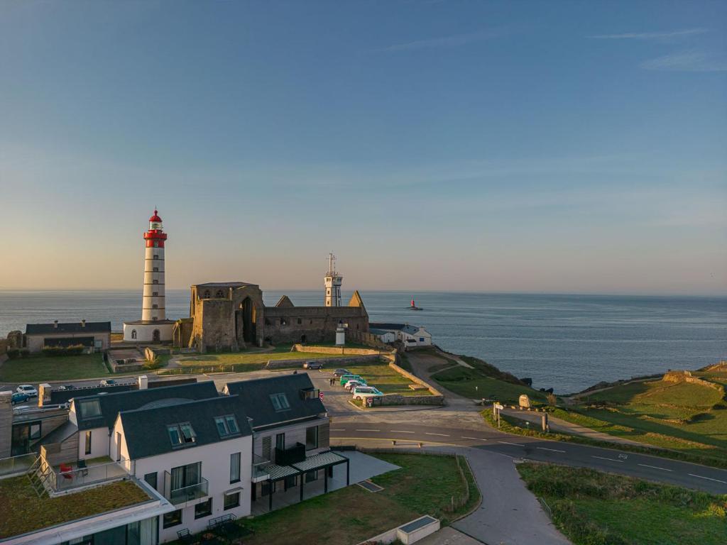 zwei Leuchttürme auf einem Hügel neben dem Meer in der Unterkunft Hostellerie de la Pointe Saint-Mathieu - SPA & Restaurant in Plougonvelin