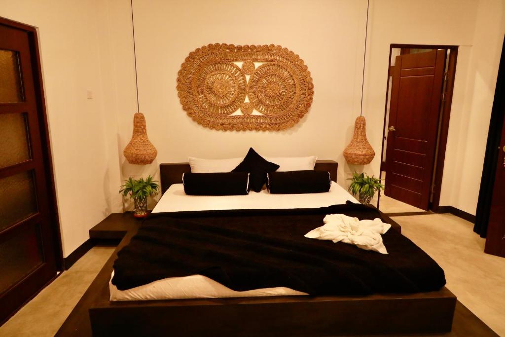 a bedroom with a large black and white bed at The Jini House in Ahangama