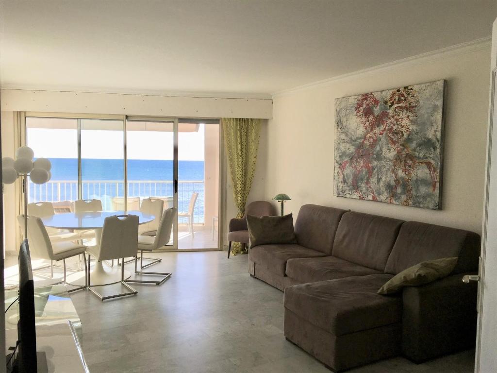 a living room with a couch and a table at Fettolina Palm Beach, Location Cannes front de mer et plage in Cannes