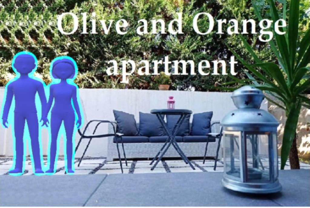 un cartel que lee vivo y naranja apartamento con dos personas y una linterna en Olive and Orange Apartment, en Mystras