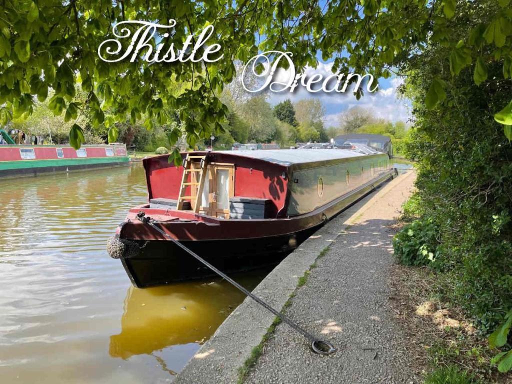 un barco estacionado a orillas de un río en Luxury boat - The Thistle Dream, en Uxbridge