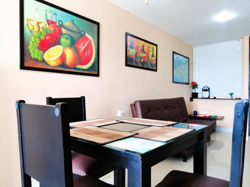 uma mesa de jantar e cadeiras com um quadro na parede em Apartahotel a 2 km del Parque del Café, 104A em Montenegro
