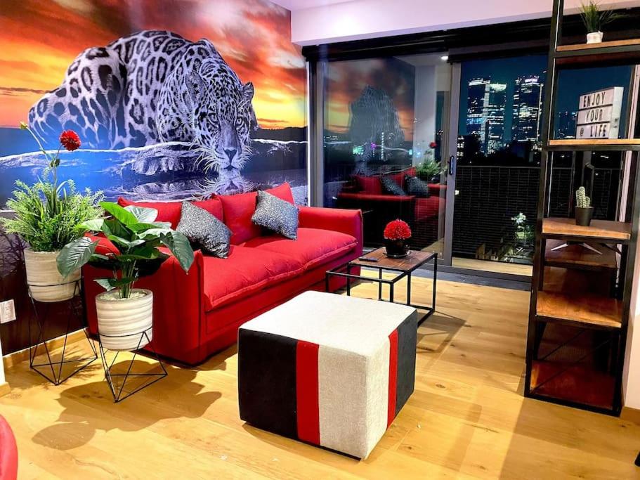 sala de estar con sofá rojo y mural de tigre en Piso 9 Con Vistas Espectaculares, 2 Recámaras 6 Personas, Gym Y 2 Parkings, en Ciudad de México
