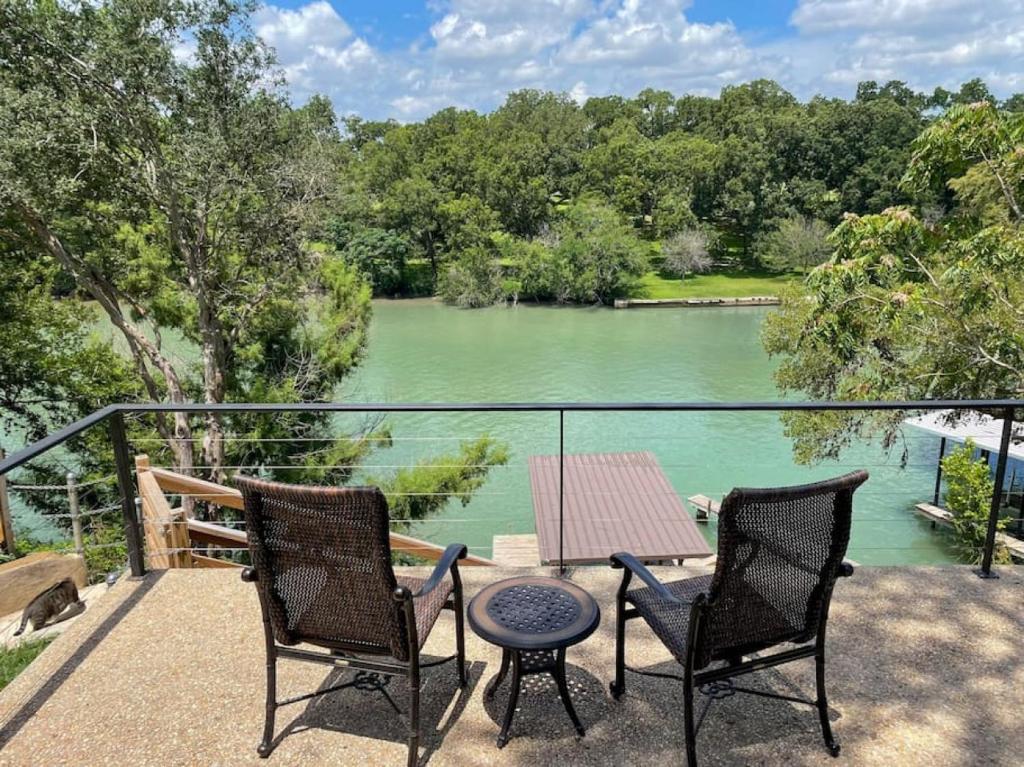 a patio with two chairs and a table and a lake at Lakeside Escape in McQueeney