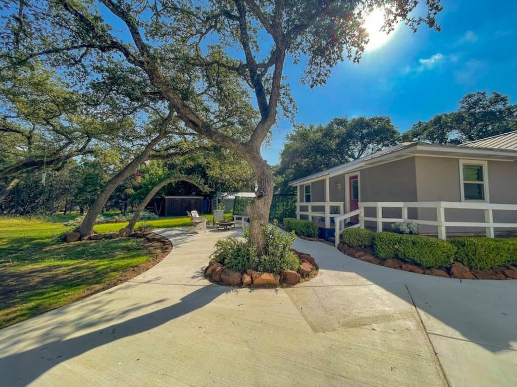 uma casa com uma árvore na entrada em The Retreat at Oak Acres Guest House em New Braunfels