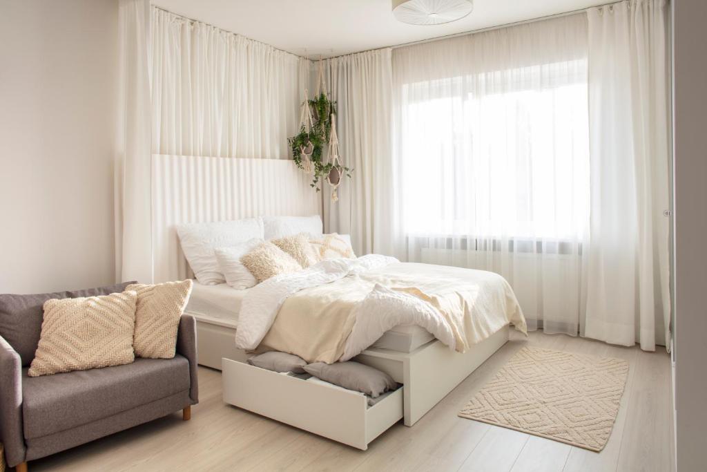 a bedroom with a bed and a couch and a window at Light Room by Zoom Apartments in Bratislava
