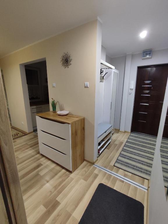 Cette chambre comprend une cuisine avec un comptoir et une porte. dans l'établissement Klimatyczne mieszkanie, à Hajnówka