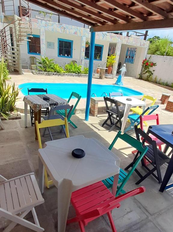 a group of tables and chairs in front of a pool at Ap 04-A 50 Metros da Praia Flats Mobiliados para 2 Pessoas in Paulista