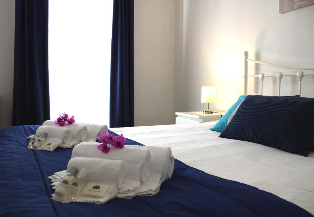 - une chambre avec des serviettes et des fleurs sur un lit dans l'établissement PDL Central Apartments - Three, à Ponta Delgada