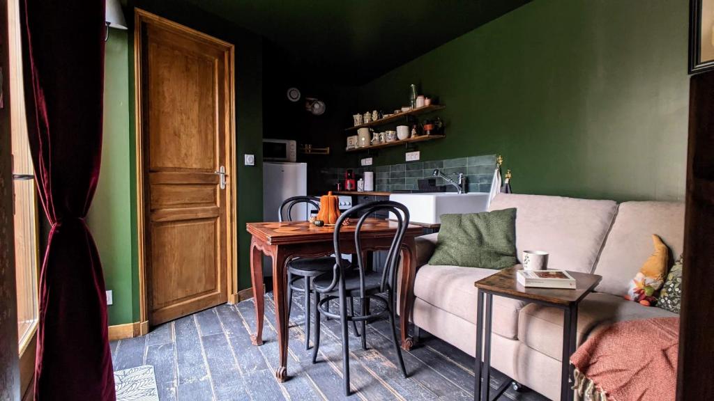 - un salon avec une table et un canapé dans l'établissement Le Cottage et la Tiny des Cartes - 2 maisons, à LʼÎle Bouchard