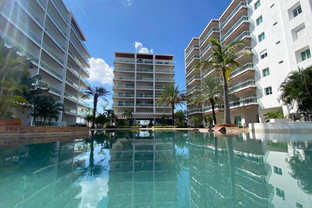 ein großer Swimmingpool mit Palmen und Gebäuden in der Unterkunft Habitación hotelera 5min de la playa by G P S rentas in Mazatlán