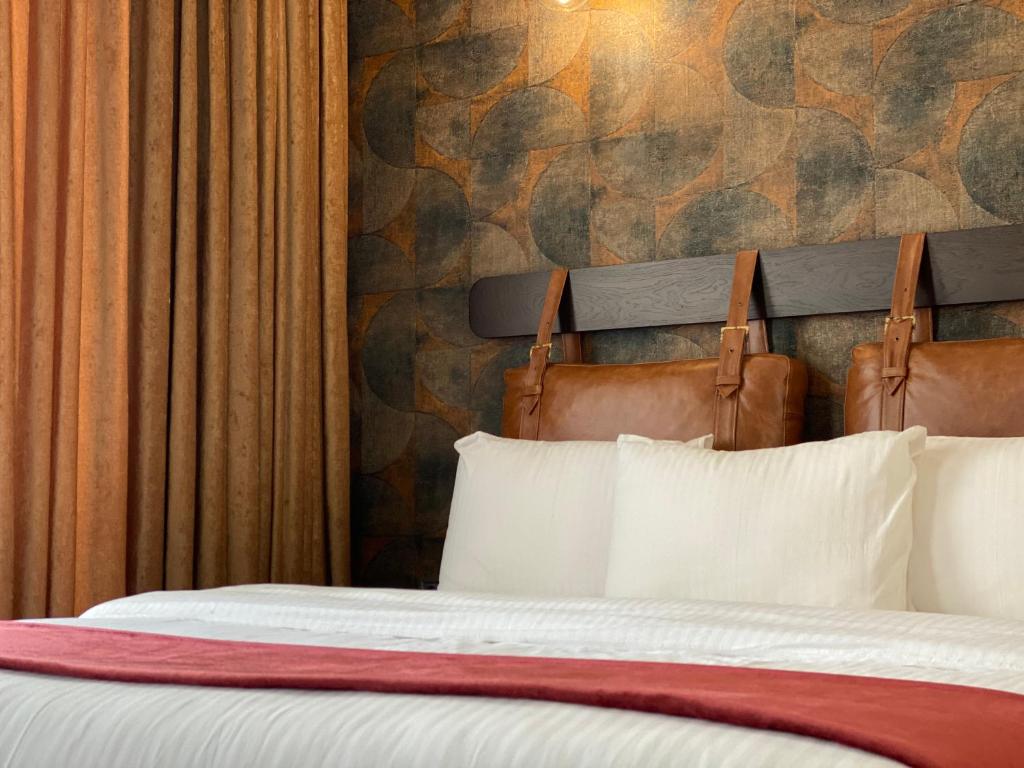 1 dormitorio con 1 cama con 2 almohadas y pared en TownHouse Tbilisi Boutique Hotel, en Tiflis