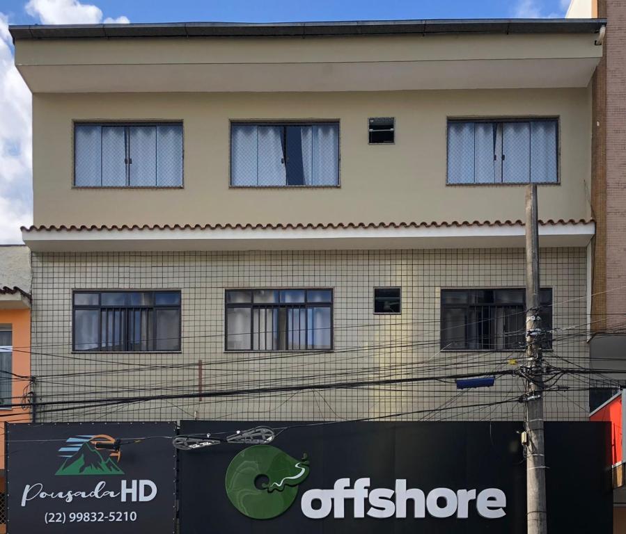 un edificio con una señal delante de él en Pousada HD en Nova Friburgo