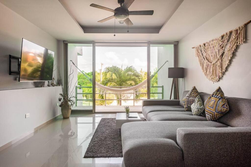 a living room with a couch and a ceiling fan at Peaceful & beautiful 3 min walking to the beach in Puerto Morelos