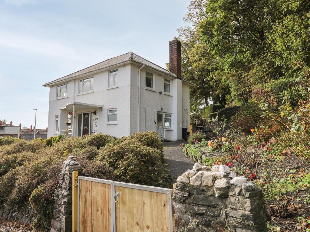 a white house with a fence in front of it at Ty Melyn in Aberystwyth