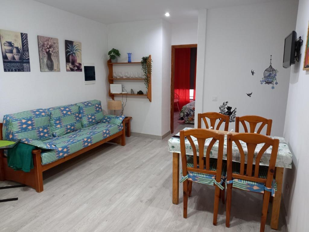 sala de estar con sofá, mesa y sillas en alojamientosmomi3, en Corralejo
